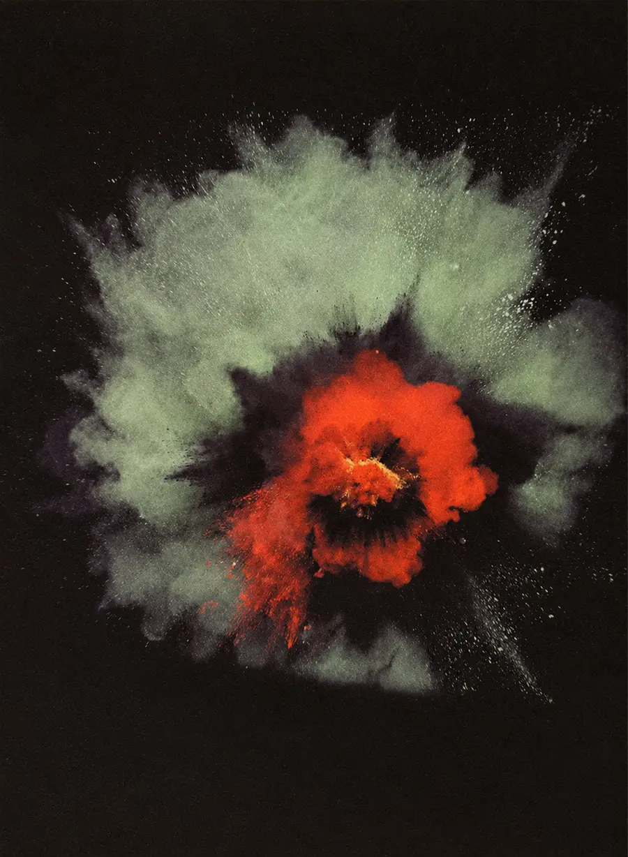 Estallido abstracto de polvo de color rojo y crema sobre fondo negro