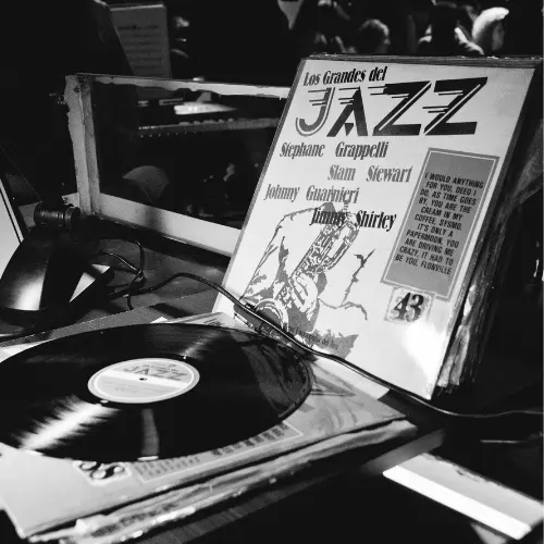 Disco de vinilo y funda «Los Grandes del Jazz» sobre una mesa, en blanco y negro