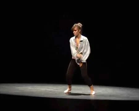Elisabet Solo bailando sola sobre el escenario del Teatro Principal, con camisa blanca y fondo negro