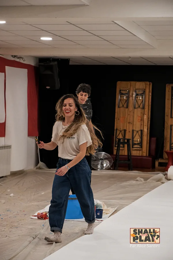 Elisabet Solo riendo durante un taller creativo, con plásticos y botes de pintura en el suelo